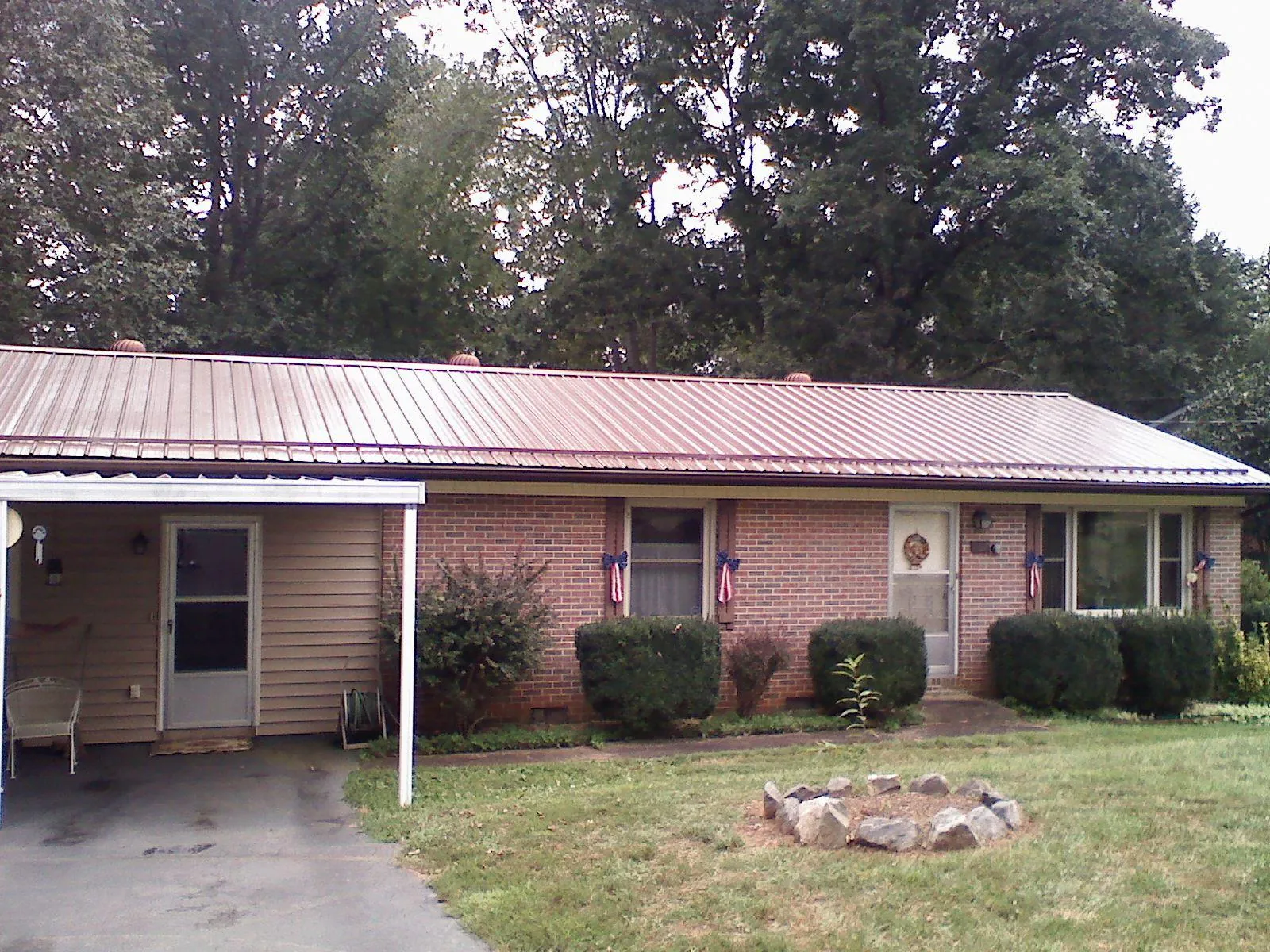 Bronze metal roof and carport on a brick ranch home — Roof Repair work by our crew in Broad Top